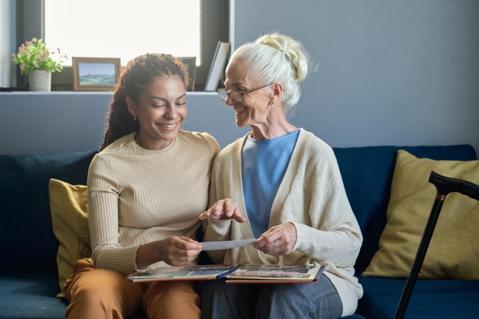 Caregiver looking at photos with elderly lady