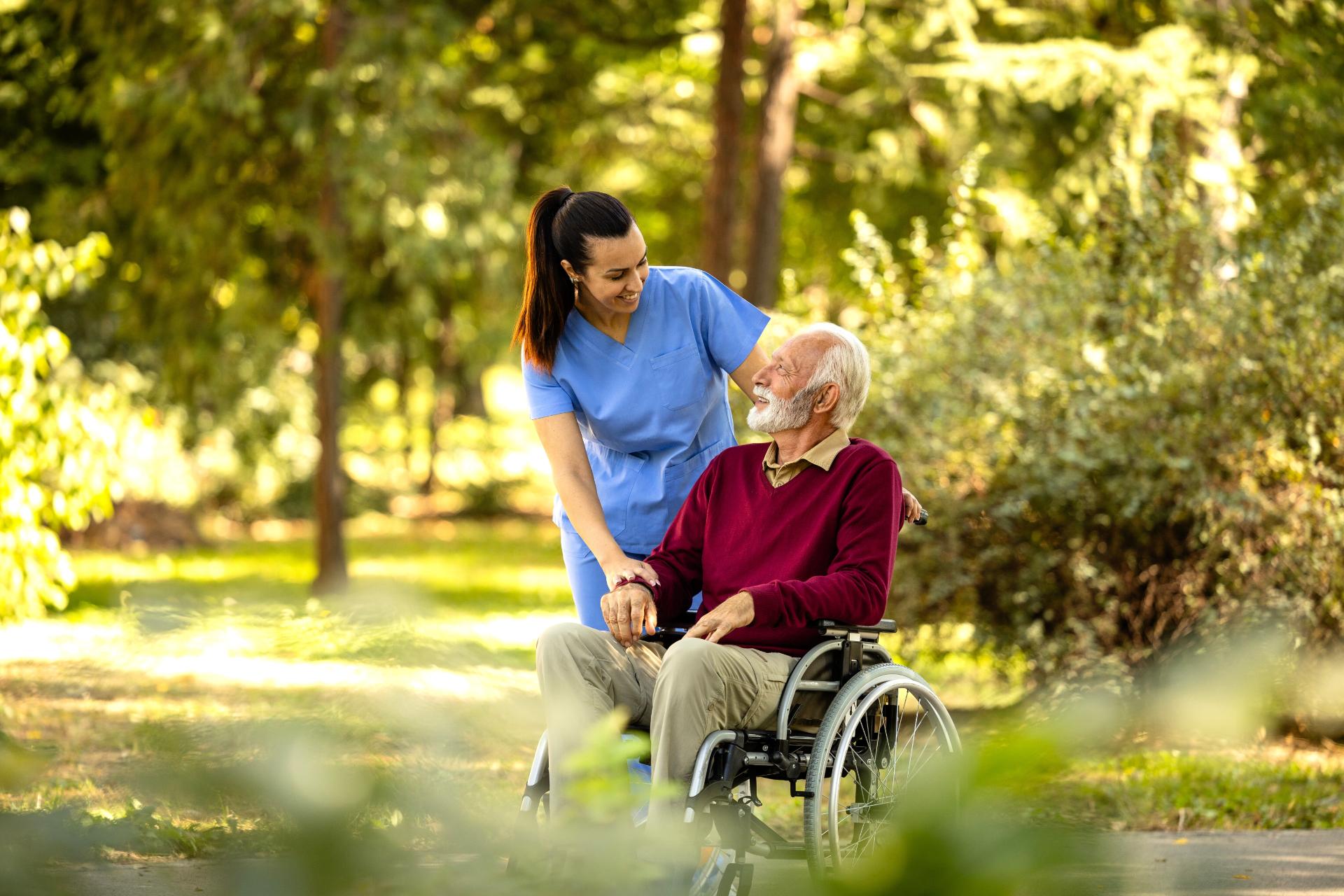 Nurse assisting elderly man on wheelchair